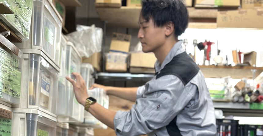 資材棚から部材を取り出す若手社員